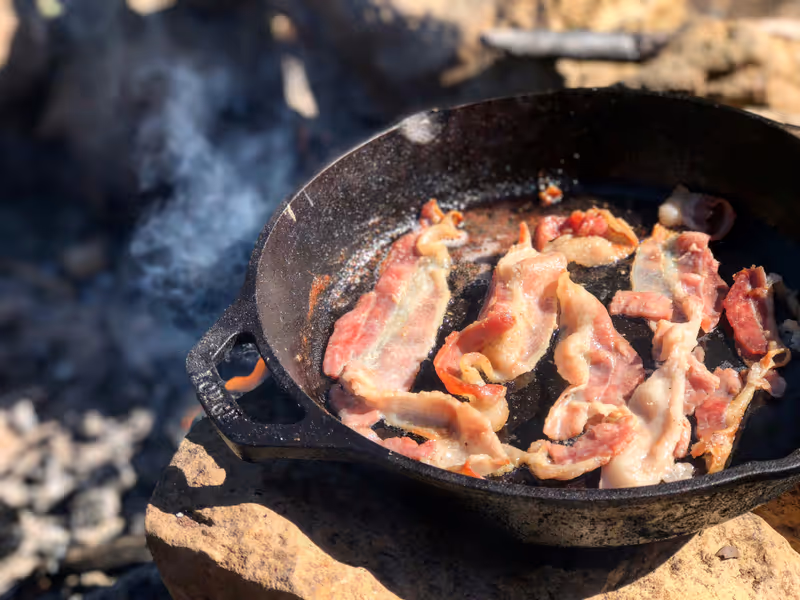 Crispy bacon strips arranged on a wooden board